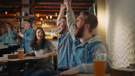A-group-of-men-and-women-in-a-pub-together-cheer-for-their-national-team-at-the-World-Cup-in-football-basketball-hockey.-Celebrate-the-goal-scored-the-puck